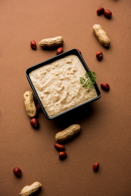 Healthy Peanut chutney made using Groundnut or Shengdana or mungfali. served in a small bowl with raw whole. Selective focus