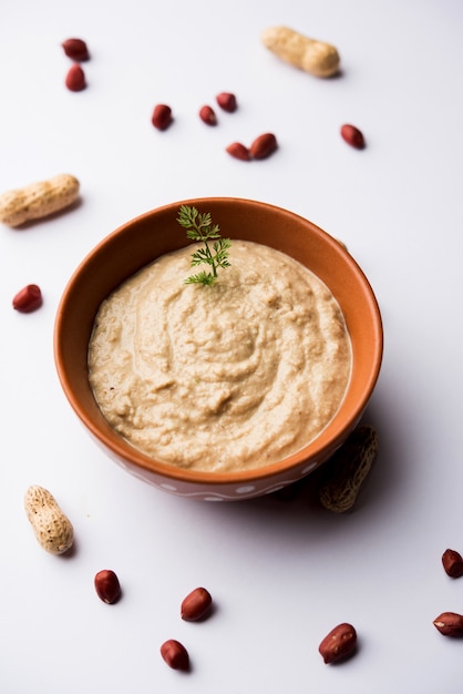 Healthy Peanut chutney made using Groundnut or Shengdana or mungfali. served in a small bowl with raw whole. Selective focus