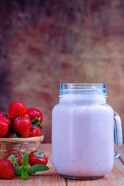 Healthy pink smoothie with strawberry in glass jars