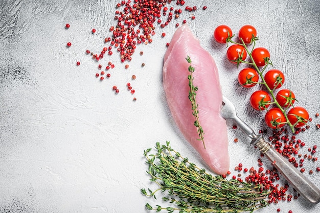 Dieta proteica sana con bistecche di filetto di petto di tacchino crudo ed erbe aromatiche sfondo bianco vista dall'alto spazio di copia