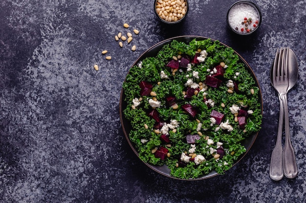 Healthy raw kale and beetroot salad with feta cheese and pine nut