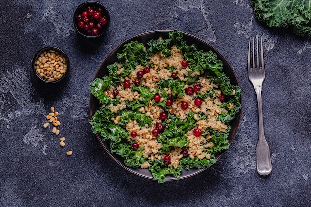 Healthy raw kale and quinoa salad with cranberry and pine nut. Top view.