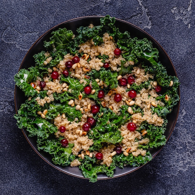 Healthy raw kale and quinoa salad with cranberry and pine nut. Top view.