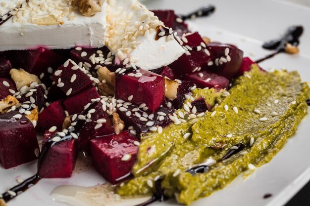 Healthy raw vegan salad with beetroot cheese and pesto