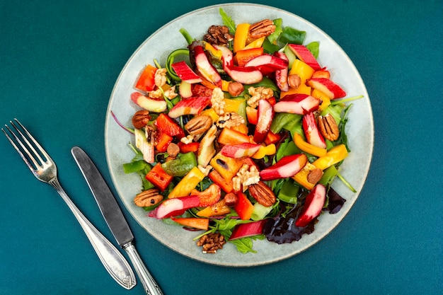 Healthy salad bowl with pepper rhubarb nuts and lettuce Clean eating