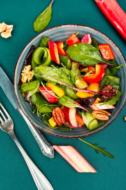 Healthy salad bowl with pepper rhubarb nuts and lettuce Clean eating