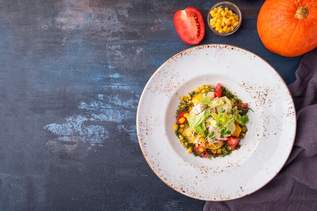 Healthy salad   chicken fillet, corn,  tomatoes and baked pumpkin. Top view.