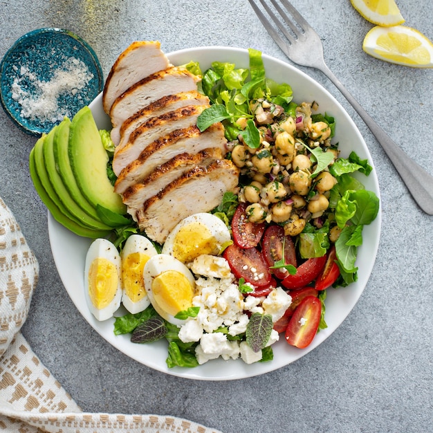 Healthy salad lunch bowl with chicken avocado and chickpeas