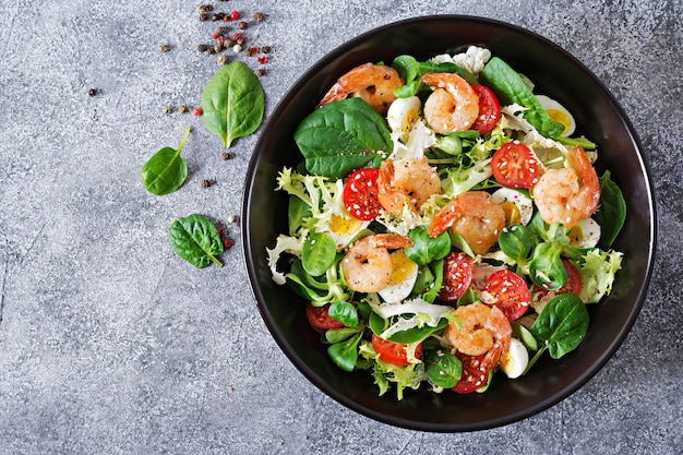 Healthy salad plate. Grilled shrimps and fresh vegetable salad and egg. 