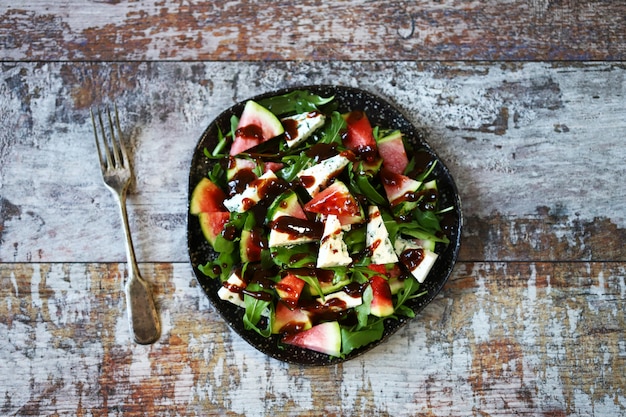 Healthy salad with arugula, blue cheese and mini watermelon. Autumn watermelon salad. Keto friendly. Vegetarian food. Fitness salad. Keto diet. Selective focus. 