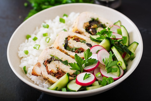Healthy salad with chicken rolls, radishes, cucumber, green onion and rice. 