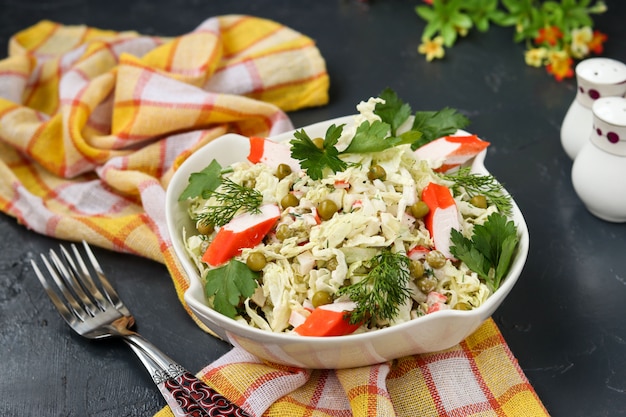 Foto insalata sana con cavolo cinese, piselli in scatola e bastoncini di granchio in una ciotola