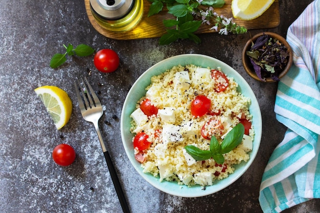 Healthy salad with couscous tomatoes feta cheese basil chili pepper and olive oil Top view