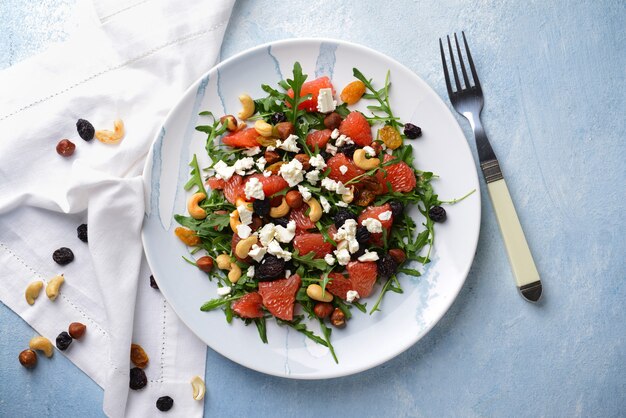 Healthy salad with feta cheese on light table