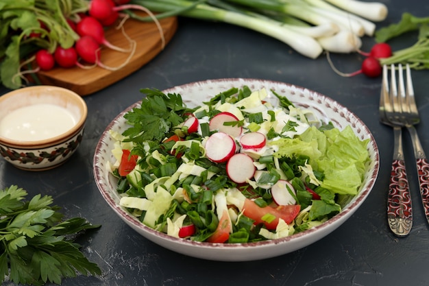 Полезный салат из свежих овощей: редька, огурцы, зеленый лук, петрушка, помидоры, капуста и шпинат