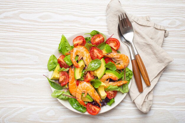 Healthy salad with grilled shrimps avocado cherry tomatoes