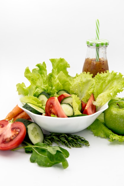 Healthy salad with juice against white background