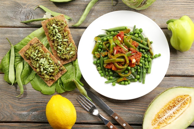 Healthy salad with peas and asparagus served on wooden table closeup