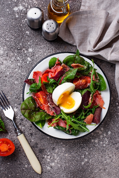 Healthy salad with prosciutto, tomato and egg