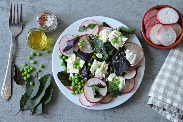 Healthy salad with radish, green peas and white cheese. Vegetarian diet salad. Keto diet.