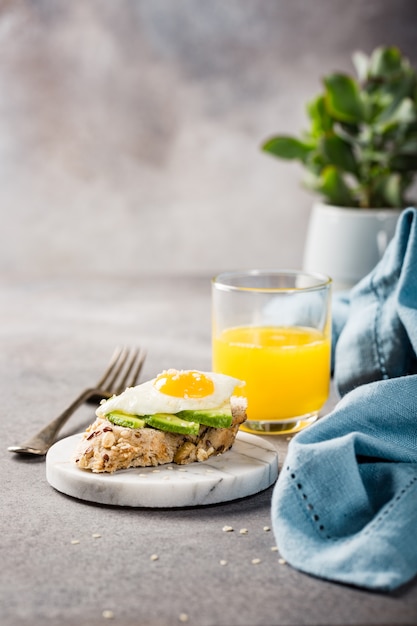 Healthy sandwich with fresh avocado and fried quail eggs