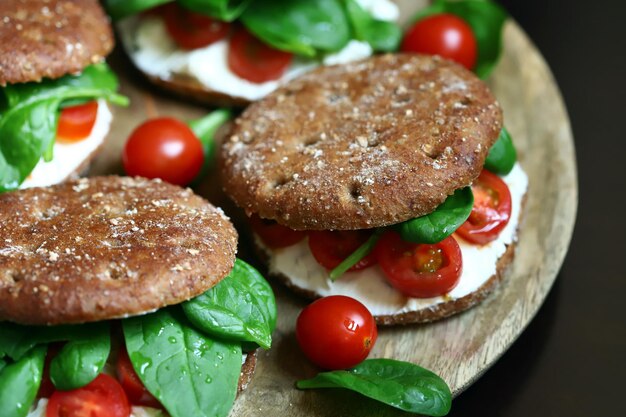 Healthy sandwiches with Philadelphia cheese spinach and cherry tomatoes with rye buns