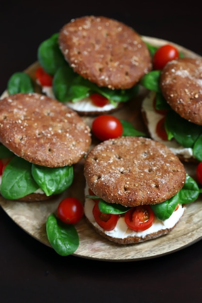 Healthy sandwiches with Philadelphia cheese spinach and cherry tomatoes with rye buns