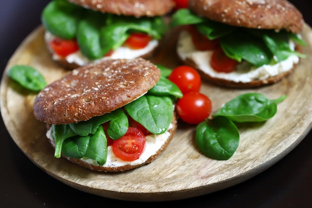 Healthy sandwiches with Philadelphia cheese spinach and cherry tomatoes with rye buns