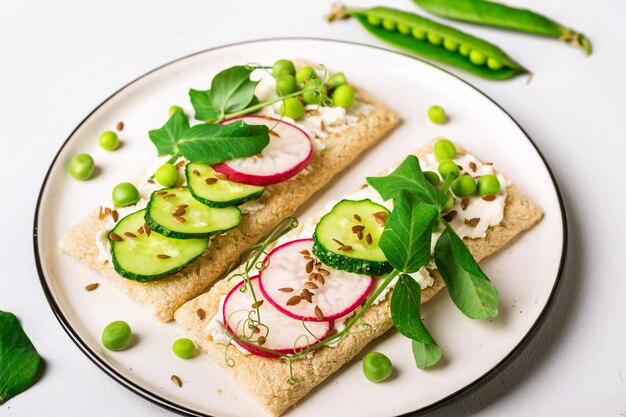 カリカリのパンに柔らかいチーズと生野菜を添えたヘルシーなサンドイッチ。