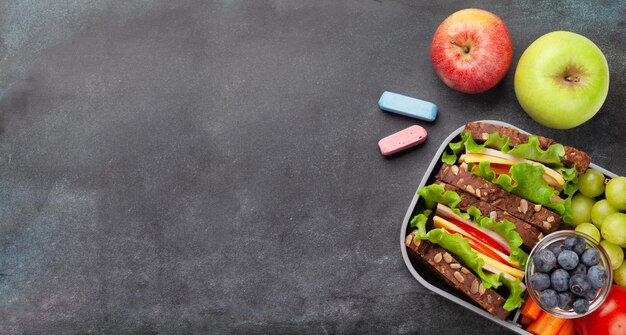 Healthy school lunch box with sandwich and fresh vegetables