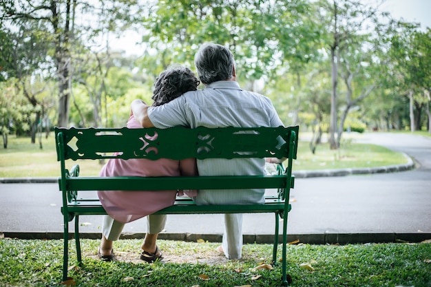 healthy senior couple relaxing  seats on the bench in the park