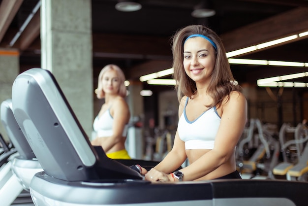 Healthy smiling young woman exercising on a treadmill in a modern gym Health and Fitness Cardio workout