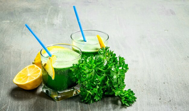 Healthy smoothie with lemon and parsley on rustic background