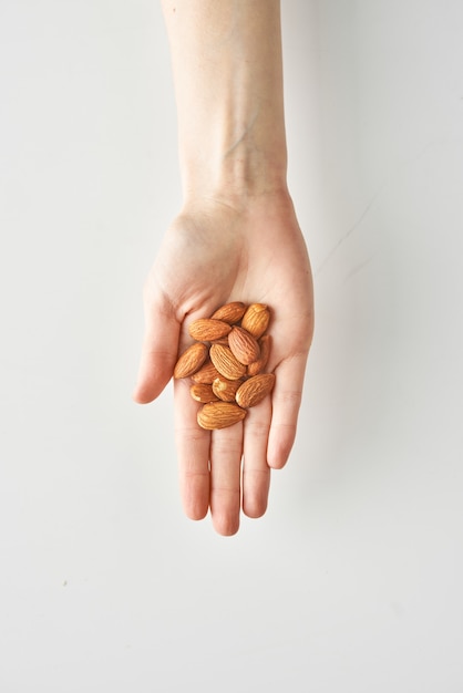 Healthy snack of almonds in woman's hand isolated