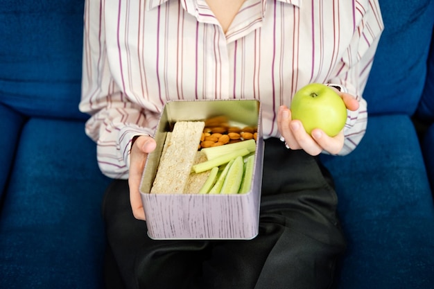 Healthy snack for office worker woman hands with lunch box at workplace during lunch break container