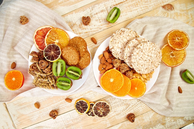 Healthy snacks variety oat granola bar,  rice crips, almond,  kiwi, dried orange