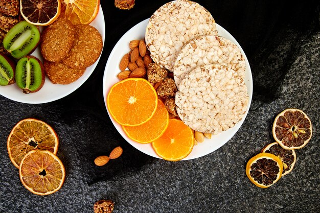 Healthy snacks -  variety oat granola bar,  rice crips, almond,  kiwi, dried orange