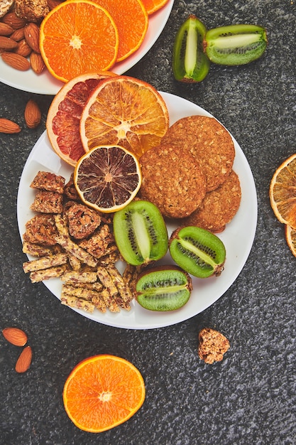 Healthy snacks -  variety oat granola bar,  rice crips, almond,  kiwi, dried orange