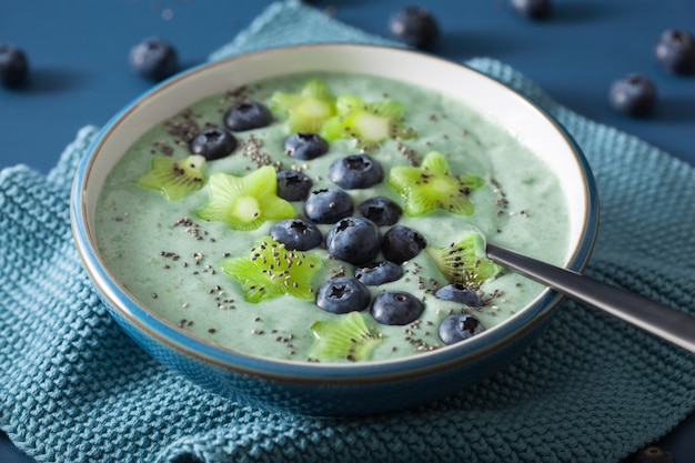 Healthy spirulina smoothie bowl with blueberry, kiwi stars, chia seed