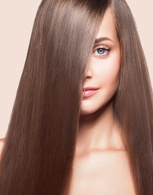 Healthy strong hair long brunette hairstyle female. Color background. Studio shot.