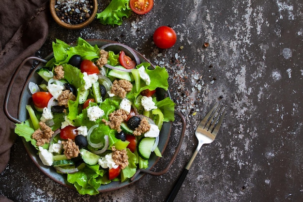 Здоровый летний обед Греческий салат с консервированным тунцом и листьями салата Вид сверху Copy space