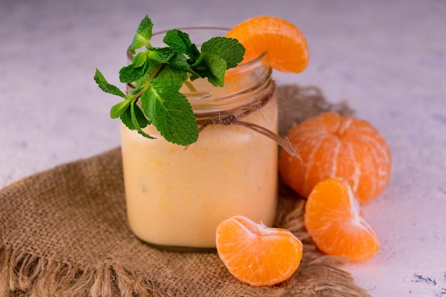 Healthy tangerine smoothie in a jar Closeup