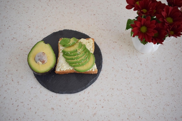 Healthy toast for breakfast with avocado, eggs, tomatoes, arugula etc.