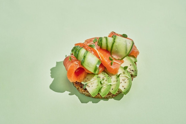 Healthy toast with spelt bread salmon fresh cucumber and avocado