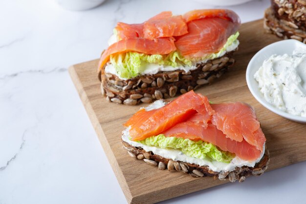 Healthy toasts with rye bread with cream cheese salmon and salad