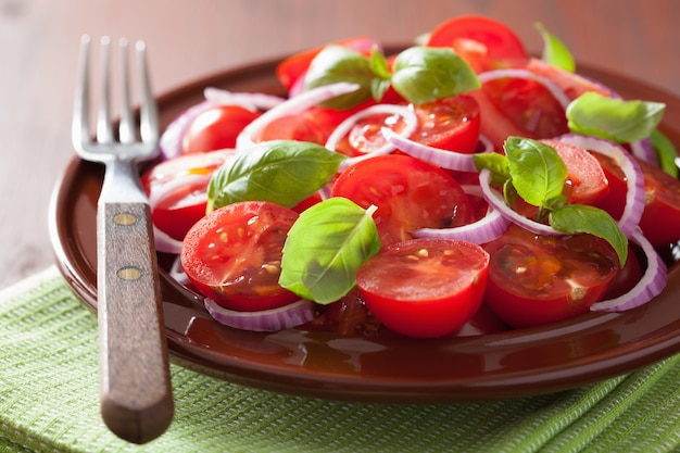 Foto sana insalata di pomodori con cipolla olio d'oliva e aceto balsamico