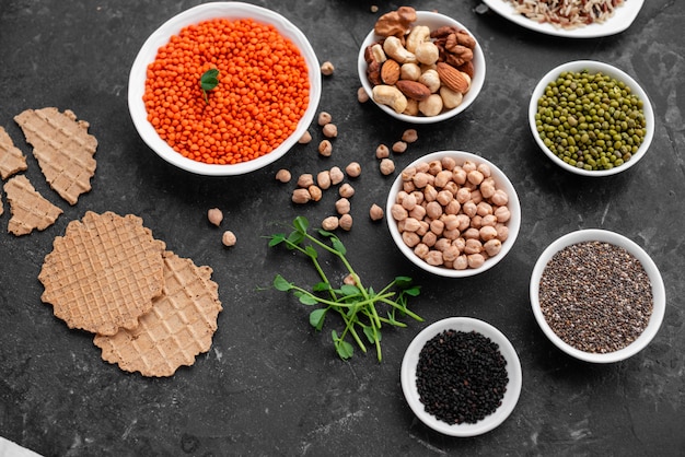 Healthy vegan food on a concrete background with copy space. nuts, beans, greens and seeds