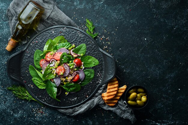 Healthy vegan salad of spinach quinoa tomatoes and vegetables Top view Rustic style