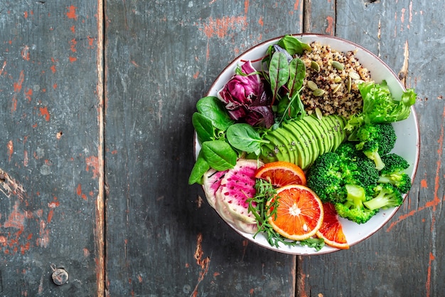 Healthy vegetable buddha bowl with fruit, vegetable and seeds. Balanced food. Delicious detox diet. Top view.