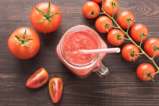 Healthy vegetable. Glass of red tomato juice on wooden table